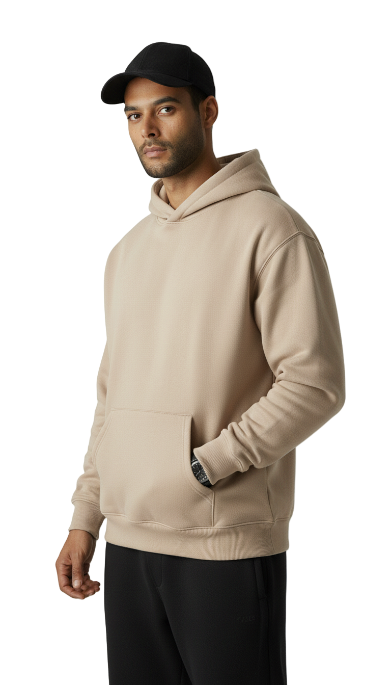 Man wearing a beige hoodie and black cap on a white background