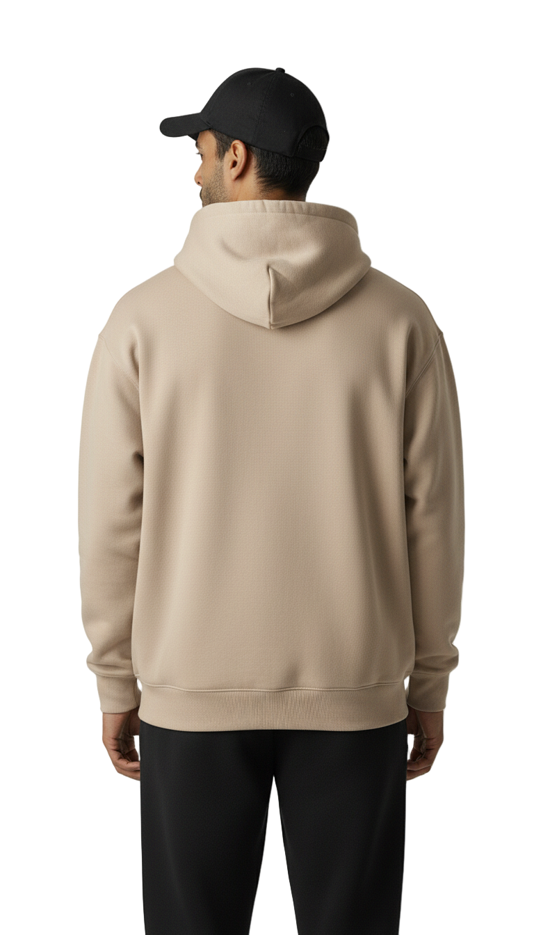 Person wearing a beige hoodie and black cap on a white background