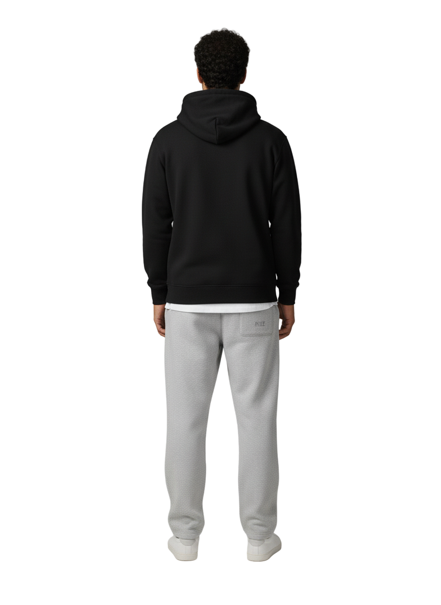 Person wearing a black hoodie and gray sweatpants on a white background