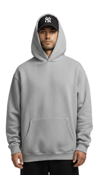 Person wearing a gray hoodie and black cap with a logo on a white background
