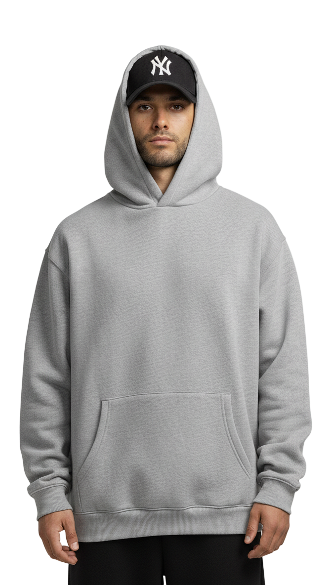 Person wearing a gray hoodie and black cap with a logo on a white background