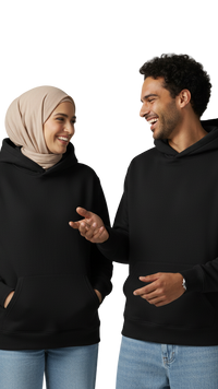 Two people wearing black hoodies and light blue jeans against a gray background