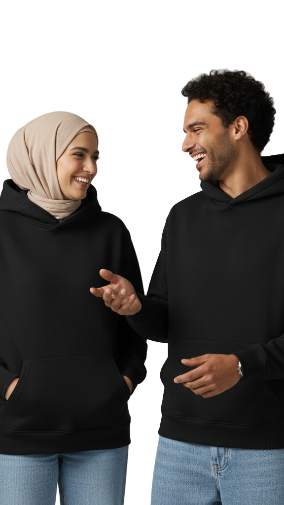 Two people wearing black hoodies and light blue jeans against a gray background